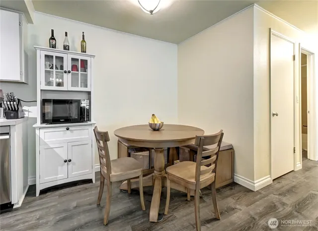 a kitchen with stainless steel appliances a dining table chairs and a refrigerator