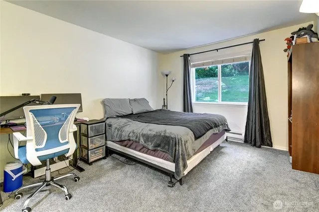 a bedroom with a bed chair and window