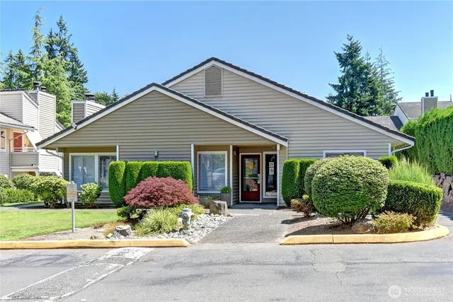 a front view of house with garage and plants