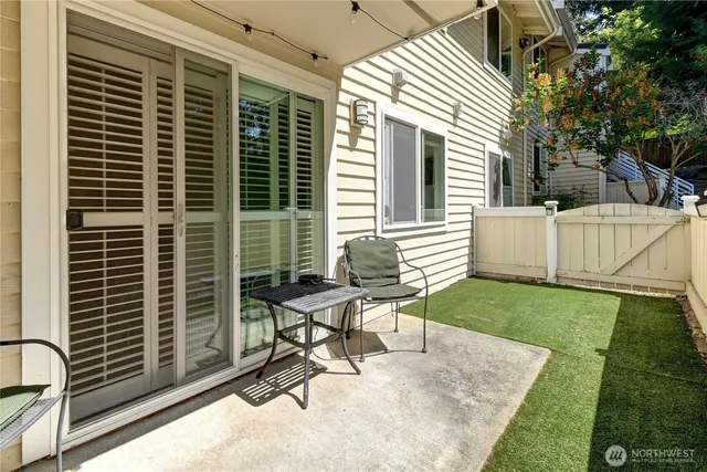 a view of a patio with a table and chairs and a barbeque