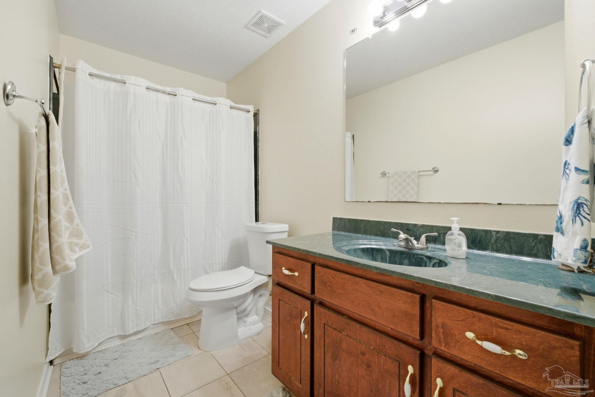 5121 Keyser Mill Road Baker, FL 32531 - Photo 21 of 52 a bathroom with a granite countertop sink a toilet and a mirror