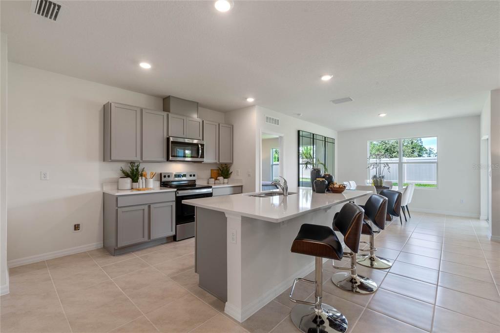3503 Nettle Loop Tavares, FL 32778 - Photo 12 of 38 a kitchen with a sink a counter top space stainless steel appliances and cabinets