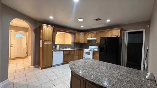 a kitchen with granite countertop stainless steel appliances and refrigerator