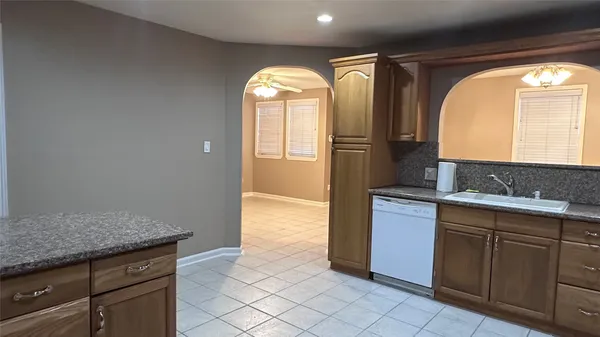 a bathroom with a granite countertop sink and mirror with bathtub