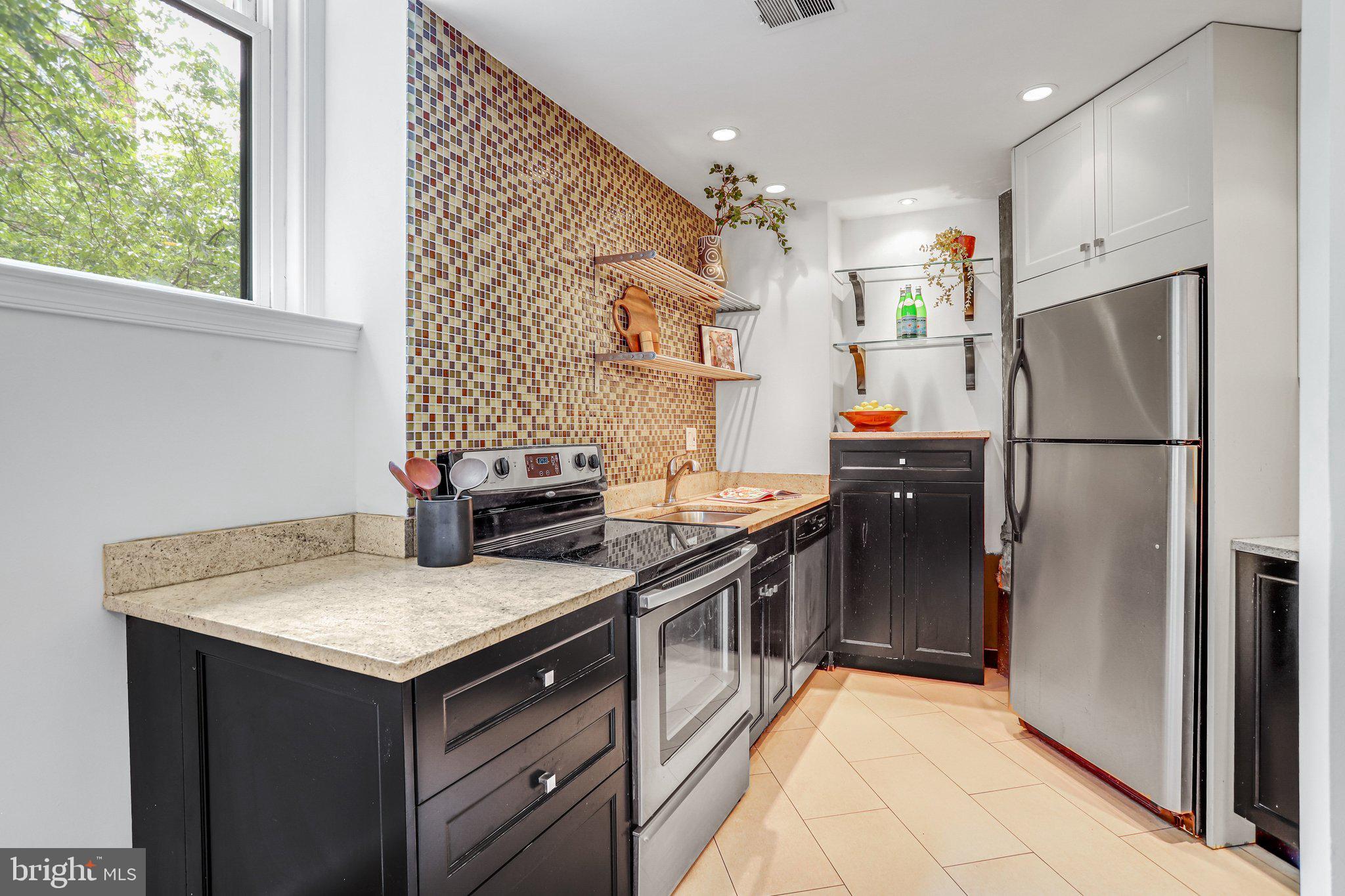 2001 16th Street Northwest, Unit 105 Washington, DC 20009 - Photo 4 of 16 a kitchen with granite countertop a refrigerator and a sink