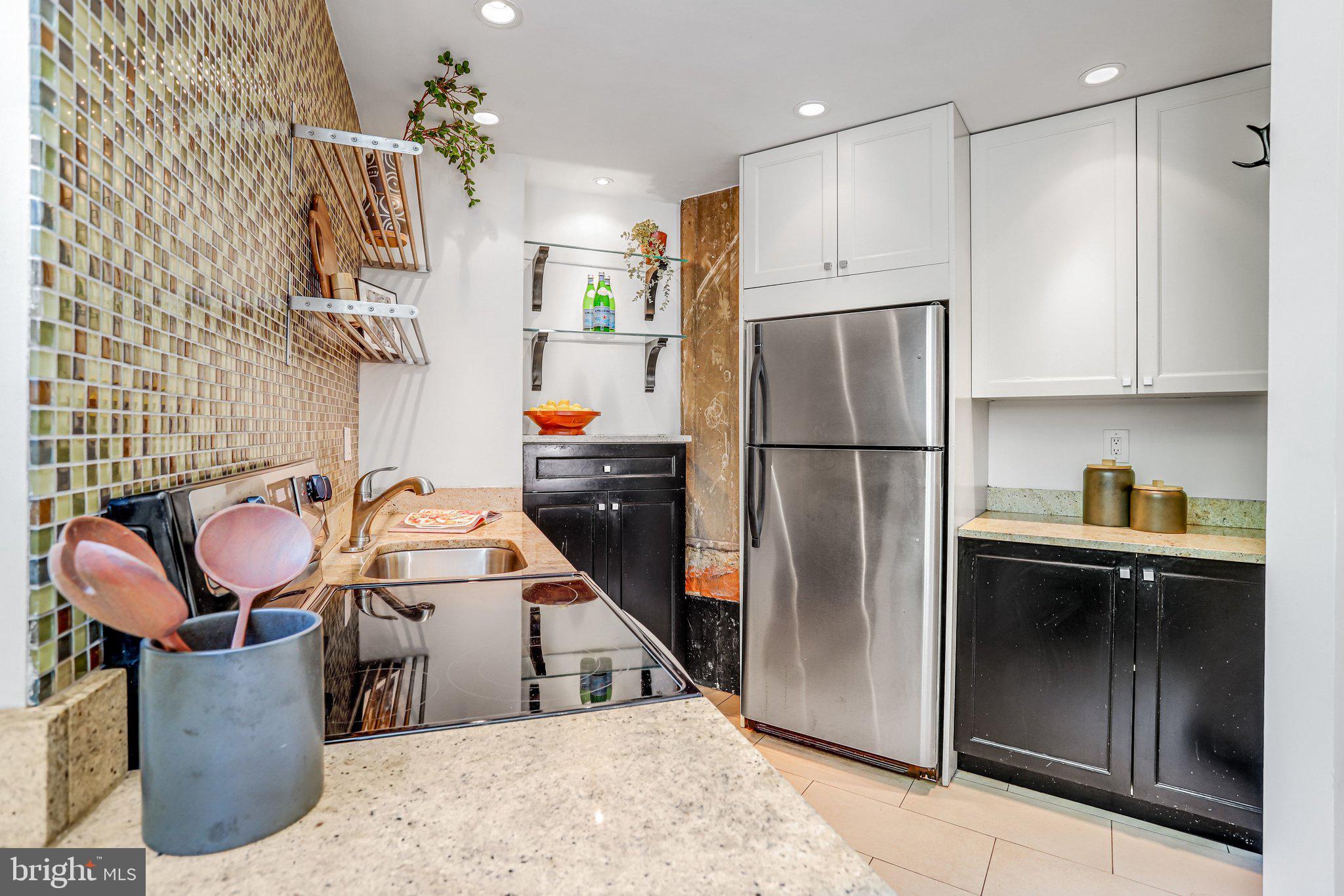 2001 16th Street Northwest, Unit 105 Washington, DC 20009 - Photo 5 of 16 a kitchen with stainless steel appliances granite countertop a refrigerator sink and stove