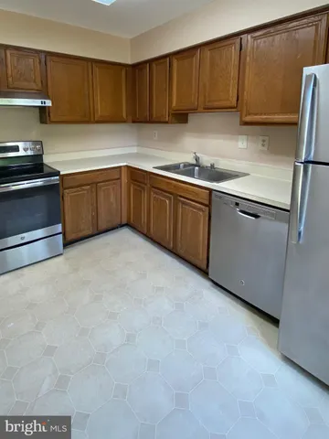 a kitchen with stainless steel appliances a refrigerator sink and cabinets