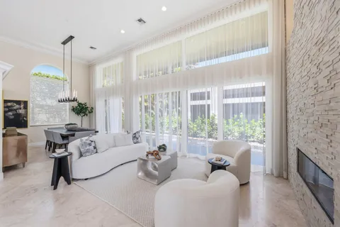 a living room with furniture a chandelier and a flat screen tv