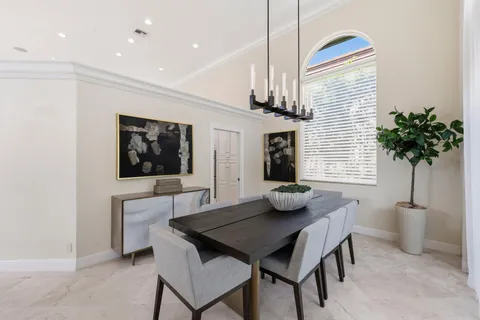 a kitchen with stainless steel appliances kitchen island granite countertop a stove a sink a dining table and chairs