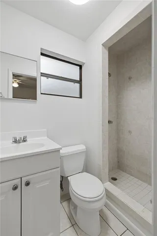 a bathroom with a toilet a sink a mirror and shower
