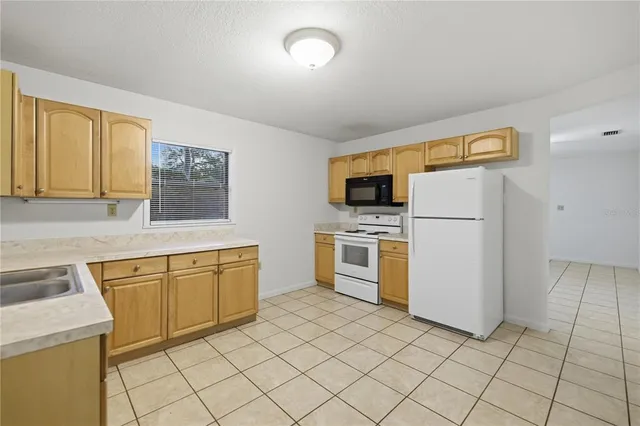 a kitchen with cabinets and white appliances