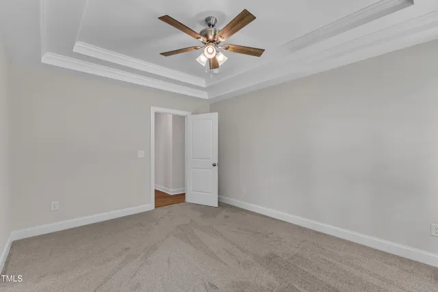 an empty room with closet and a ceiling fan