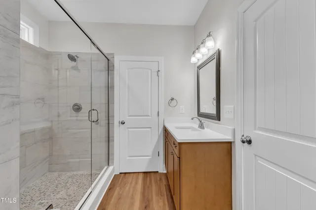 a bathroom with a sink vanity granite tub and shower