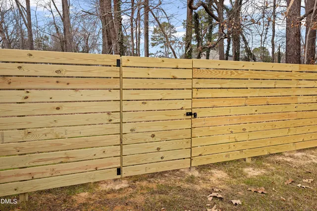a house that is sitting in the grass with large trees