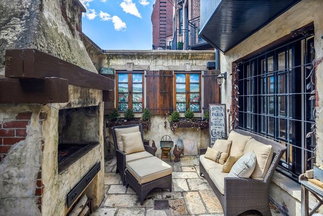 a view of a patio with table and chairs under an umbrella with a small yard