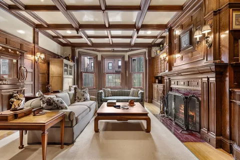 a living room with furniture a fireplace and lots of windows