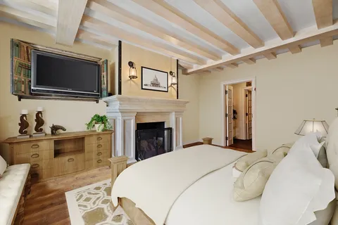 a spacious bedroom with a bed and a flat screen tv