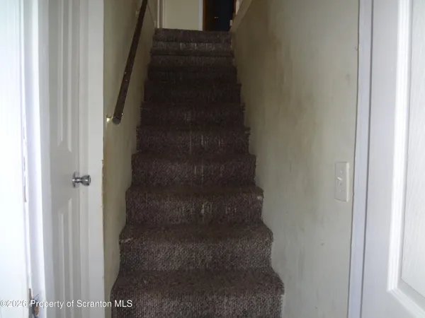 a view of a hallway with wooden floor and windows