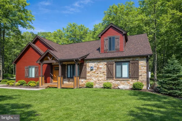 a front view of a house with a yard and green space
