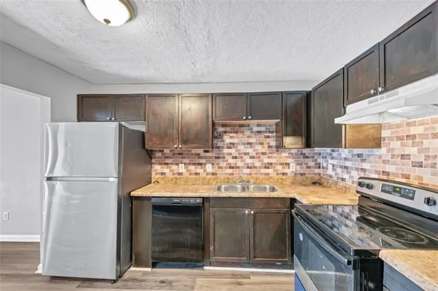 a kitchen with a refrigerator and a stove top oven
