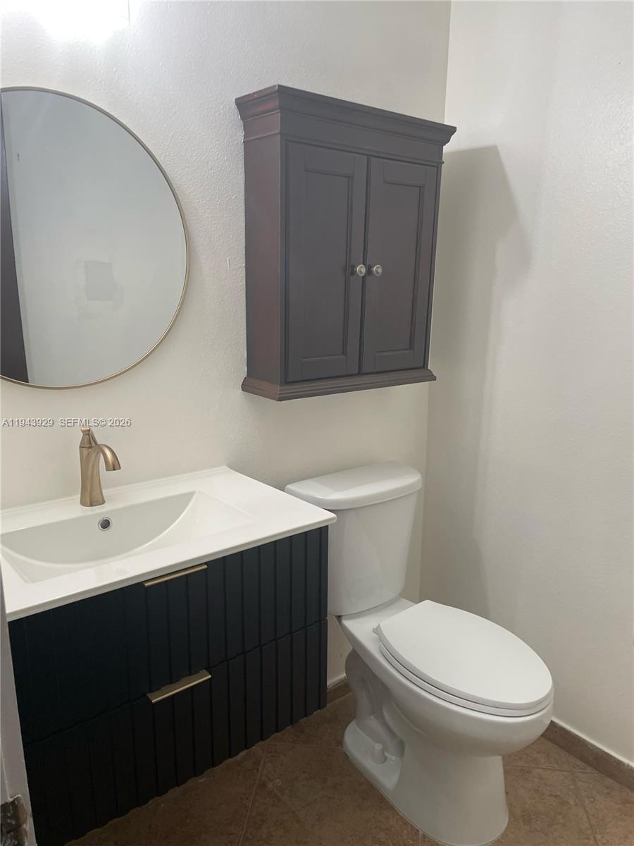 11115 West Okeechobee Road, Unit 154 Hialeah Gardens, FL 33018 - Photo 13 of 30 a bathroom with a toilet a sink and mirror