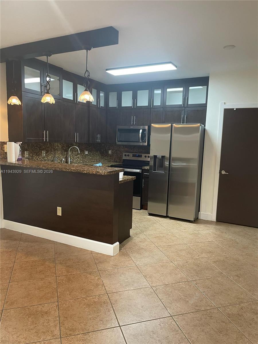 11115 West Okeechobee Road, Unit 154 Hialeah Gardens, FL 33018 - Photo 2 of 30 a kitchen with stainless steel appliances granite countertop a refrigerator and a stove