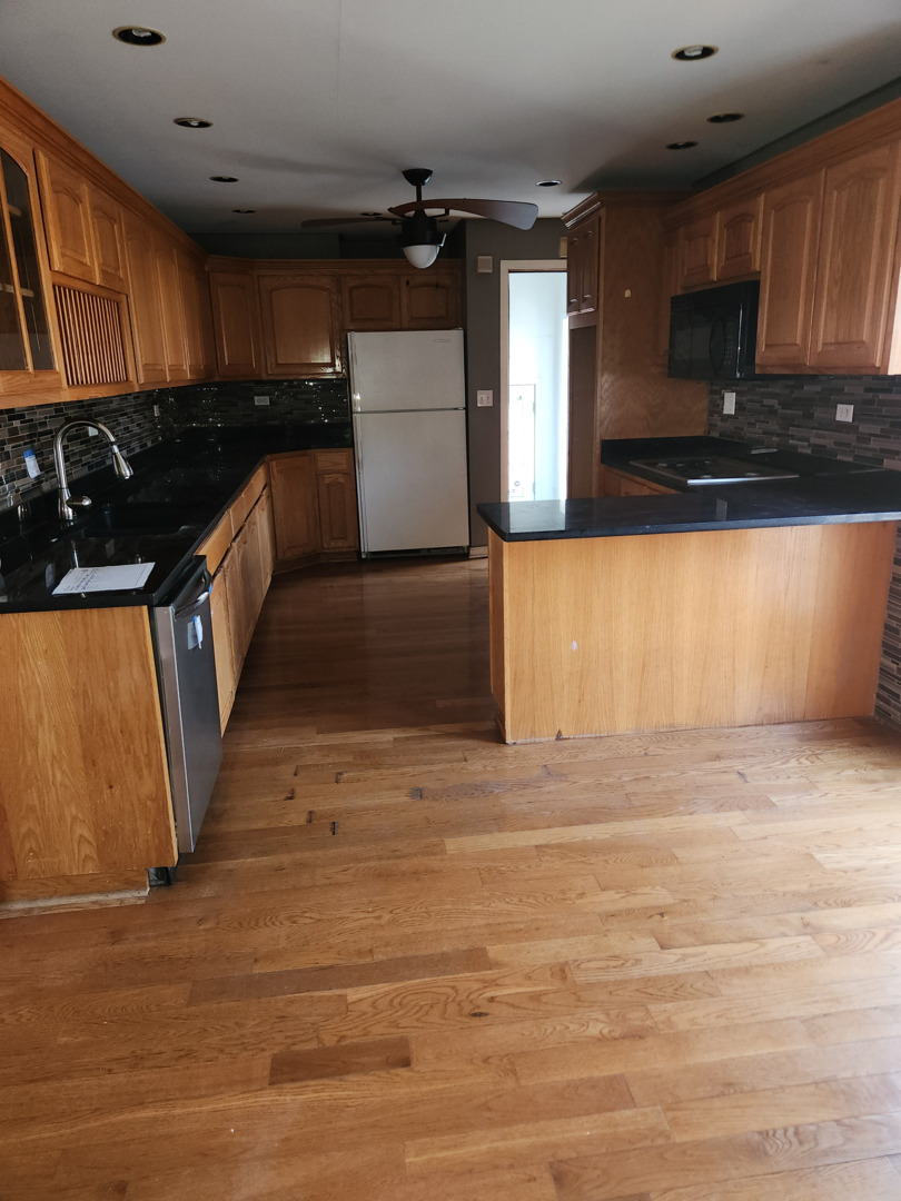 3756 West 85th Place Chicago, IL 60652 - Photo 3 of 7 a kitchen with granite countertop a stove and cabinets
