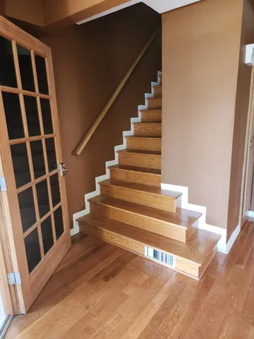 a view of entryway and hall with wooden floor