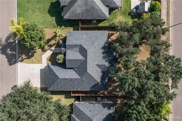 an aerial view of a house with large trees