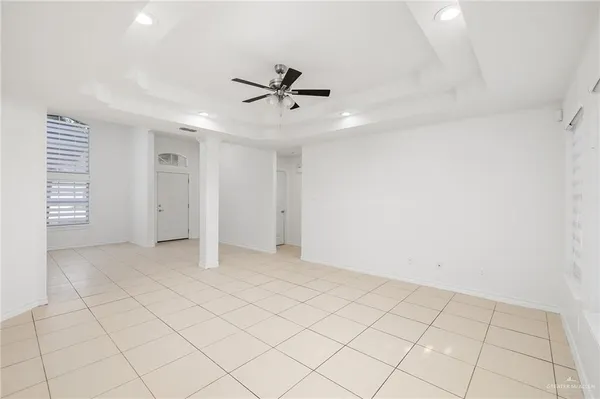 an empty room with windows and fan