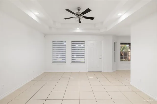 an empty room with windows and ceiling fan