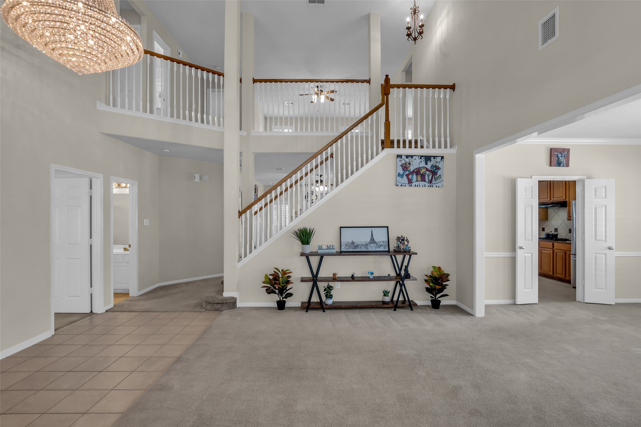 6807 Chapelfield Lane Houston, TX 77049 - Photo 8 of 42 This spacious home features a grand foyer with high ceilings, elegant staircase, and an open layout. The neutral palette, tile and carpet flooring, and ample natural light create a welcoming atmosphere. A large chandelier adds a touch of luxury, with easy access to adjacent rooms.