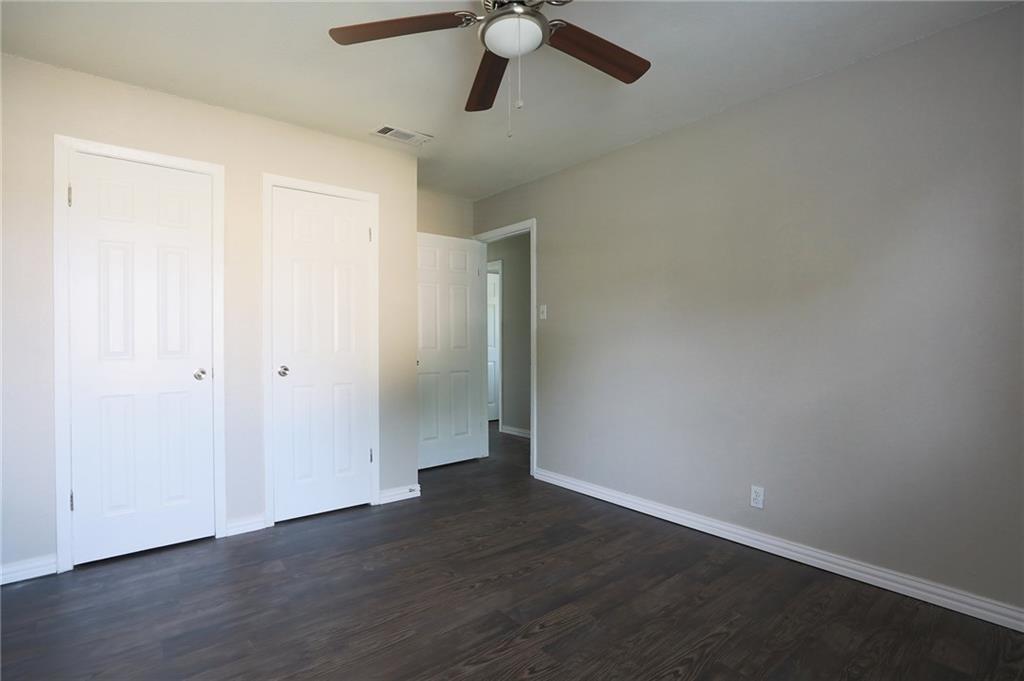 1410 Ransom Street Pflugerville, TX 78660 - Photo 13 of 22 Unfurnished bedroom featuring dark wood-style flooring, two closets, and a ceiling fan