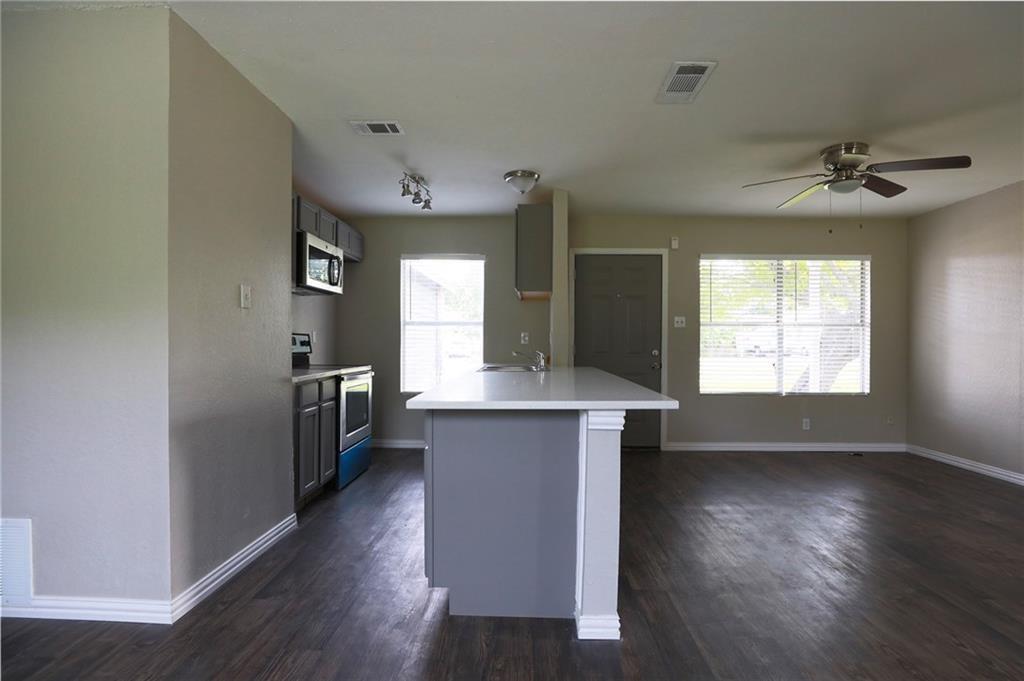 1410 Ransom Street Pflugerville, TX 78660 - Photo 6 of 22 Kitchen with gray cabinetry, stainless steel appliances, a center island with sink, dark wood-style flooring, and ceiling fan