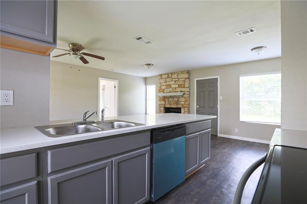 1410 Ransom Street Pflugerville, TX 78660 - Photo 7 of 22 Kitchen featuring light countertops, dishwashing machine, dark wood finished floors, and gray cabinets