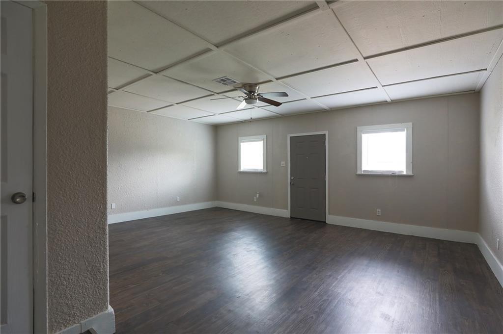 1410 Ransom Street Pflugerville, TX 78660 - Photo 9 of 22 Empty room featuring a textured wall, dark wood-style flooring, and a ceiling fan