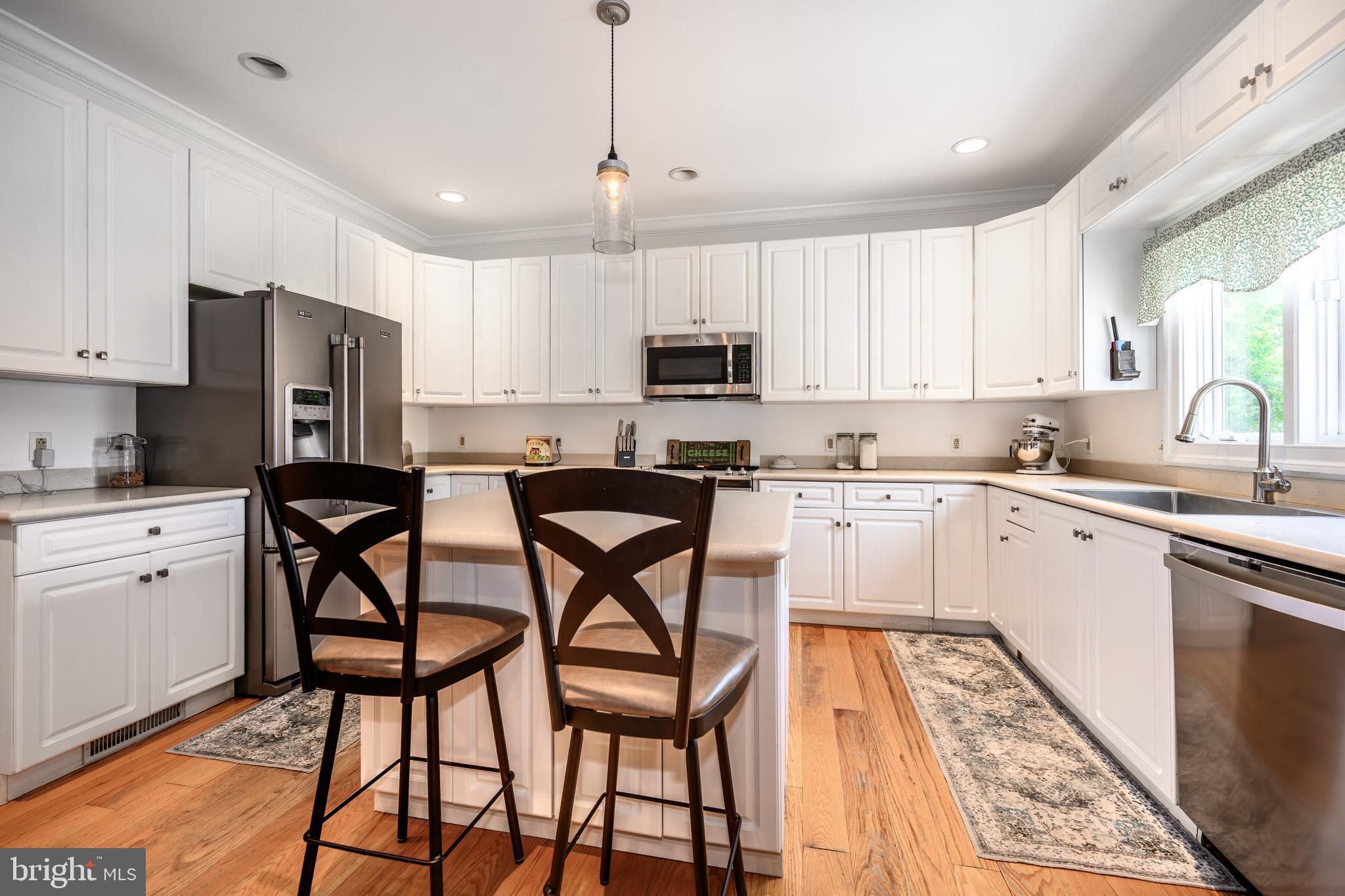 1009 South Washington Street Easton, MD 21601 - Photo 28 of 54 a kitchen with stainless steel appliances granite countertop a stove a sink dishwasher a refrigerator and white cabinets with wooden floor