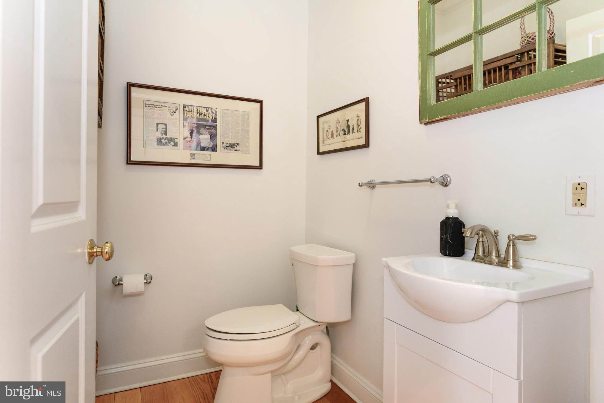 1009 South Washington Street Easton, MD 21601 - Photo 31 of 54 a bathroom with a toilet sink and mirror