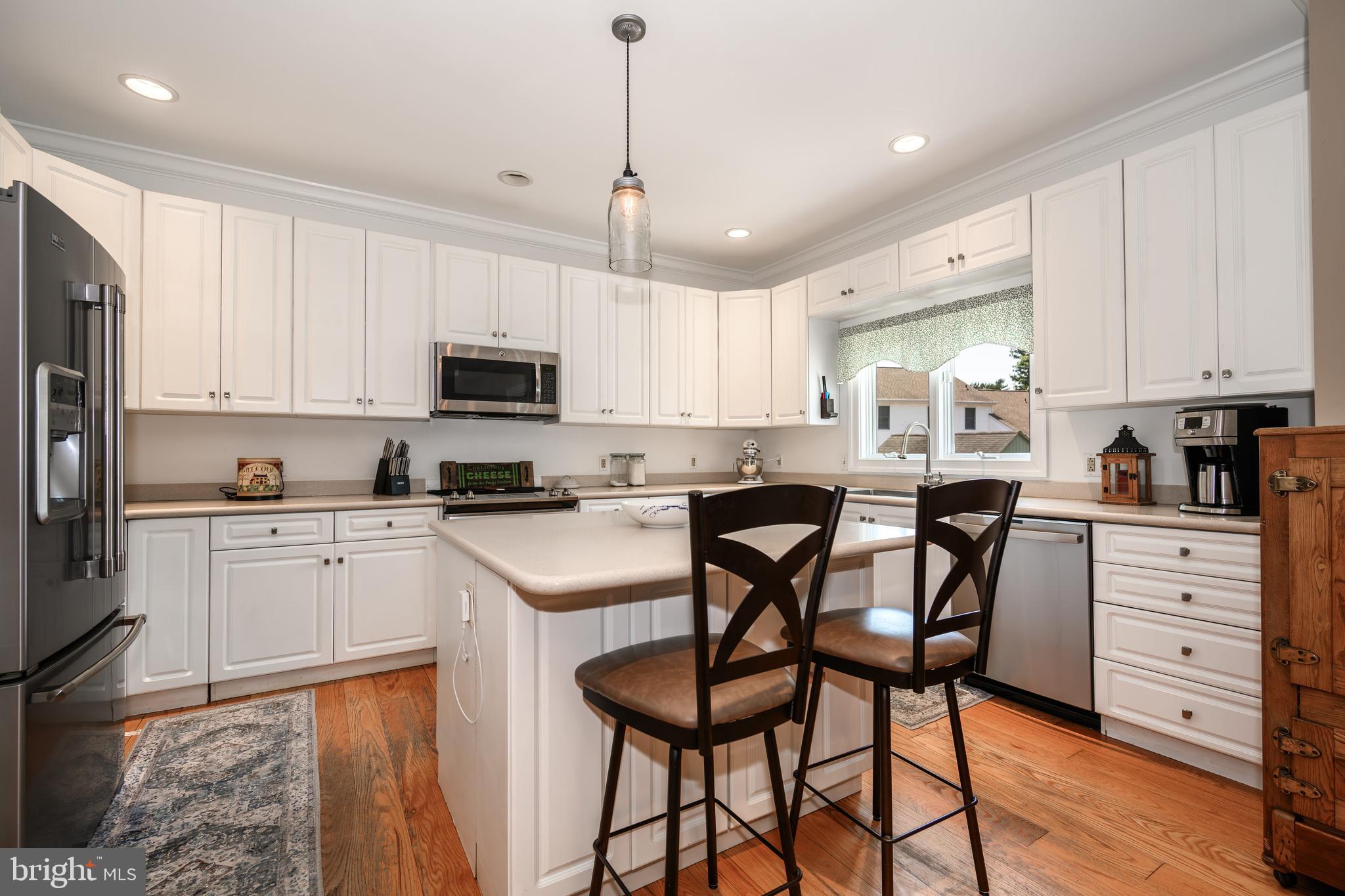 1009 South Washington Street Easton, MD 21601 - Photo 4 of 54 a kitchen with stainless steel appliances kitchen island granite countertop a table chairs microwave and sink