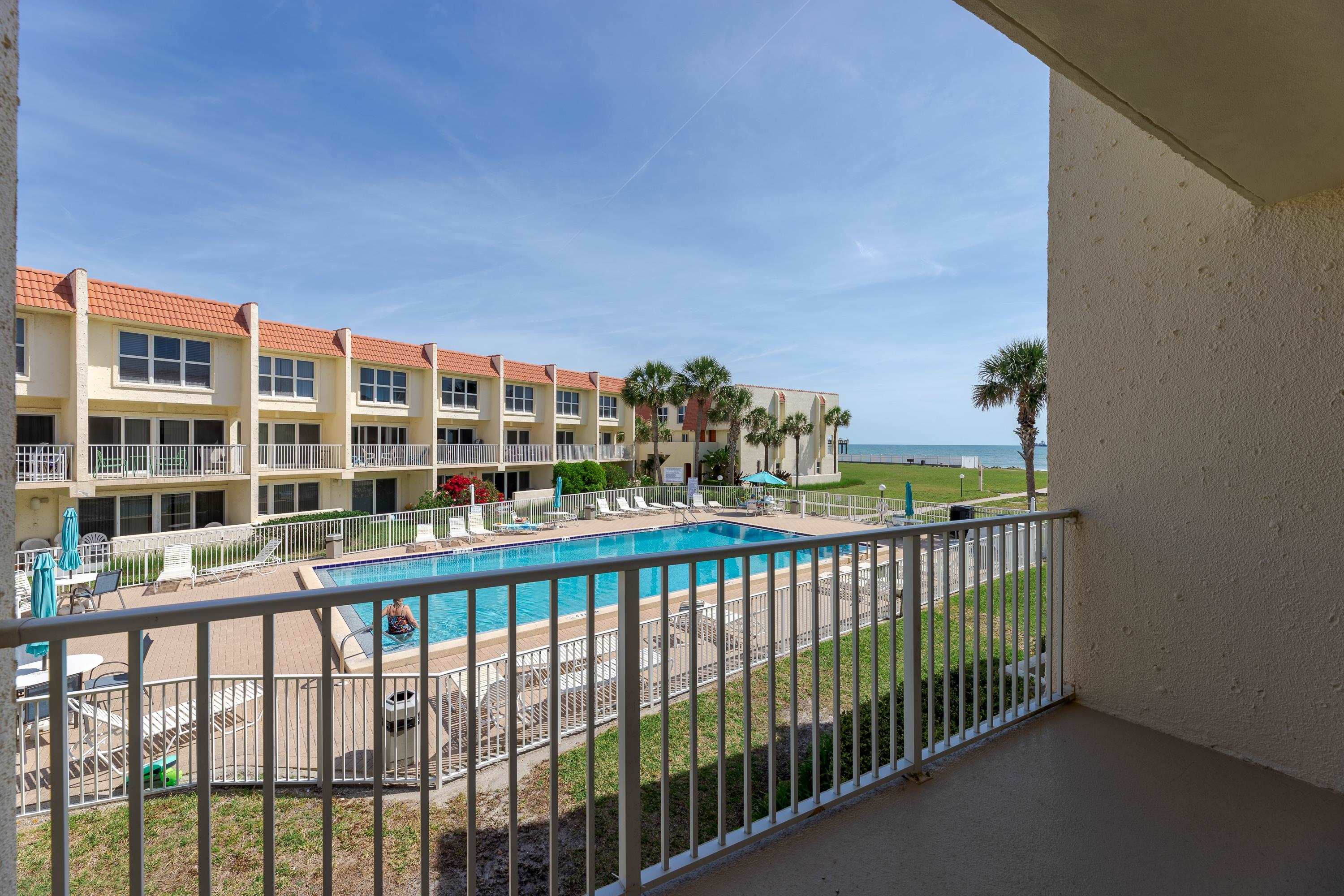 a view of a balcony with a floor to ceiling window and wooden fence