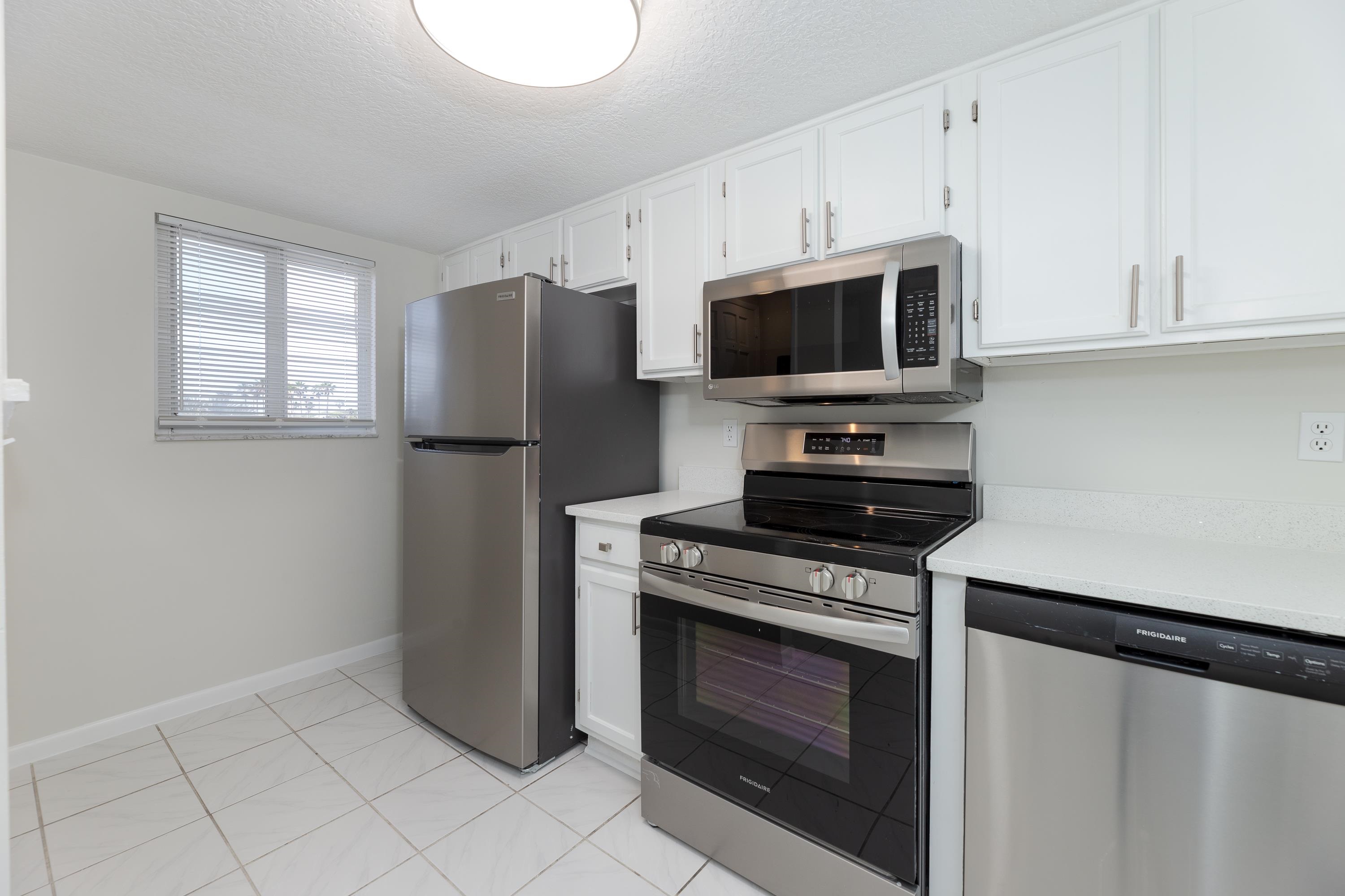 390 A1A Beach Boulevard, Unit 48 St. Augustine, FL 32080 - Photo 3 of 24 a kitchen with stainless steel appliances a stove microwave and refrigerator