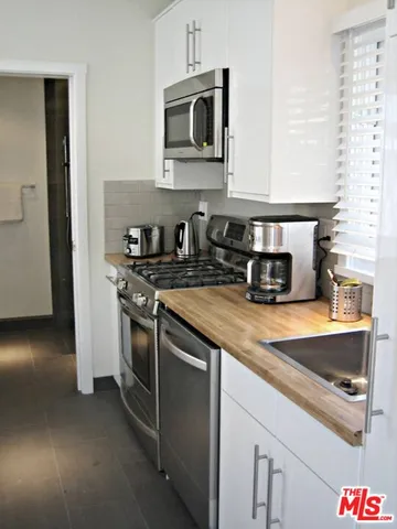 a kitchen with stainless steel appliances granite countertop a sink stove and microwave