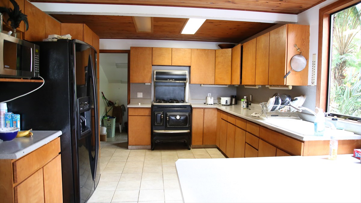 82-1213 Greenwell Mountain Road Captain Cook, HI 96704 - Photo 4 of 5 a kitchen with stainless steel appliances kitchen island granite countertop a refrigerator and a sink