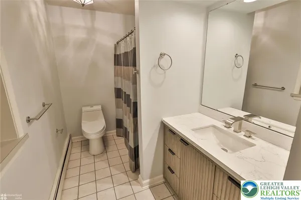 a bathroom with a sink a toilet and a mirror