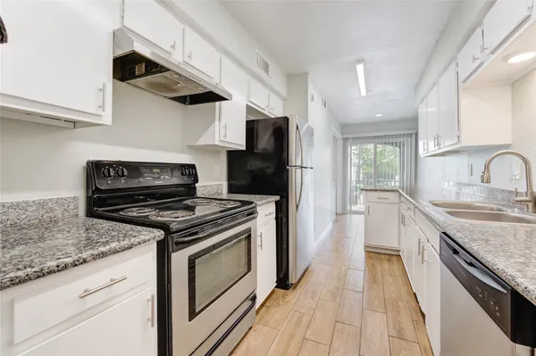 a kitchen with stainless steel appliances granite countertop a stove and a sink
