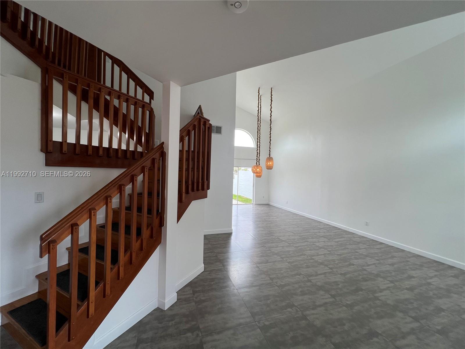 15511 Southwest 59th Street Miami, FL 33193 - Photo 12 of 34 a view of staircase with lots of frames on wall and wooden floor