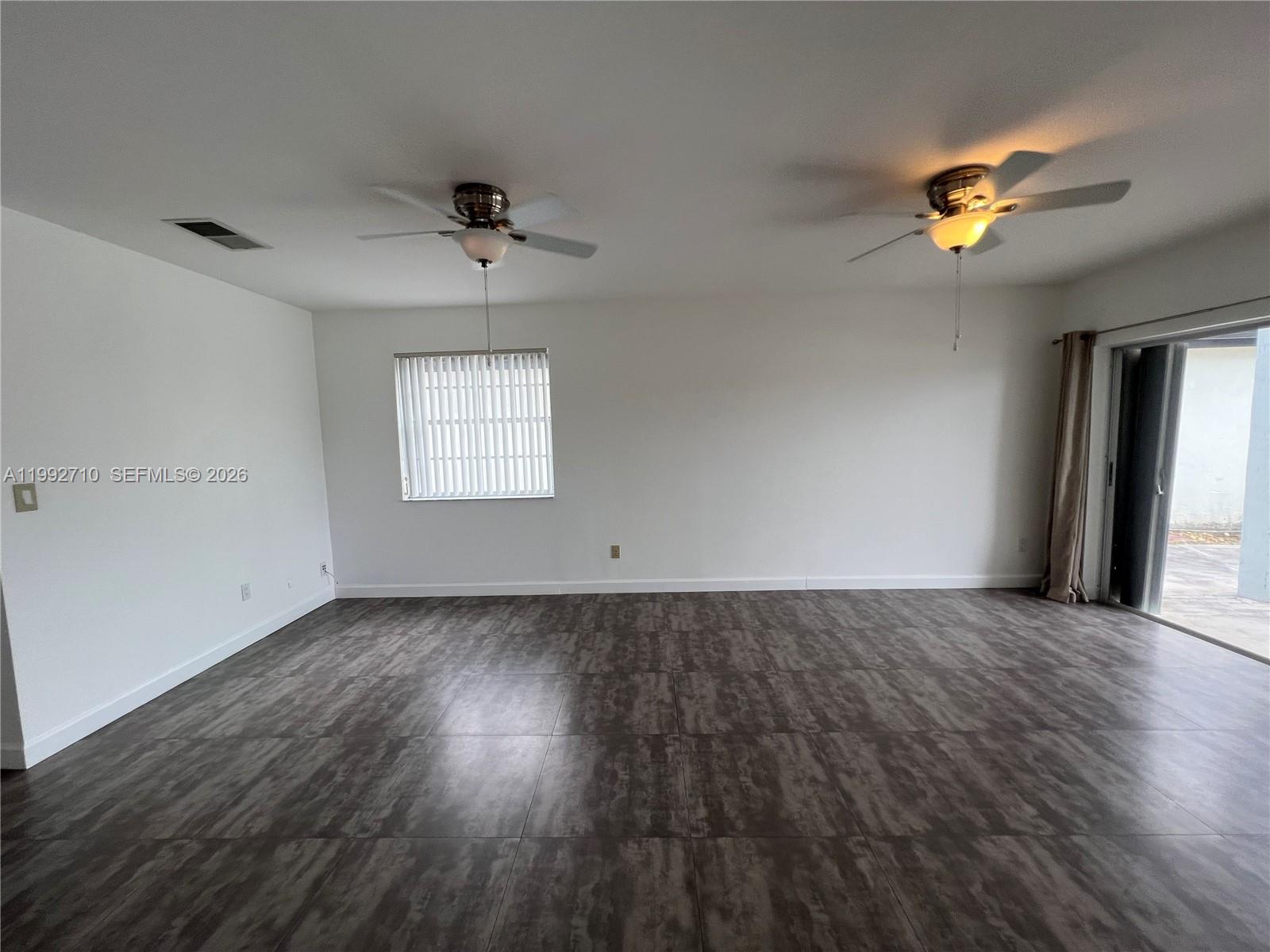 15511 Southwest 59th Street Miami, FL 33193 - Photo 13 of 34 wooden floor in an empty room with a window