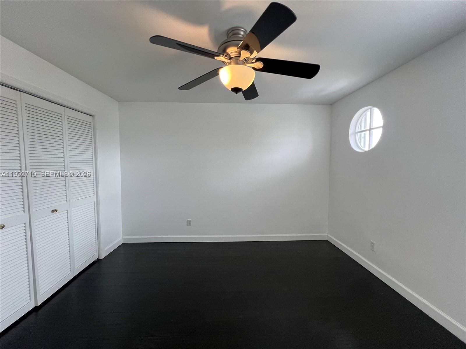 15511 Southwest 59th Street Miami, FL 33193 - Photo 23 of 34 an empty room with a ceiling fan and wooden floor