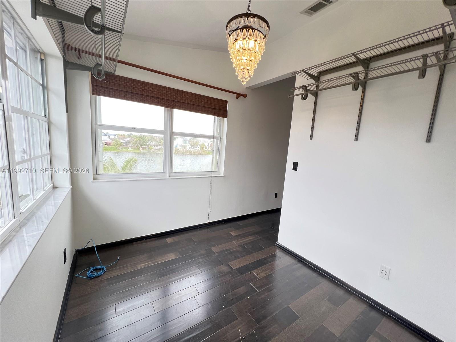 15511 Southwest 59th Street Miami, FL 33193 - Photo 24 of 34 a view of an empty room with wooden floor and a window
