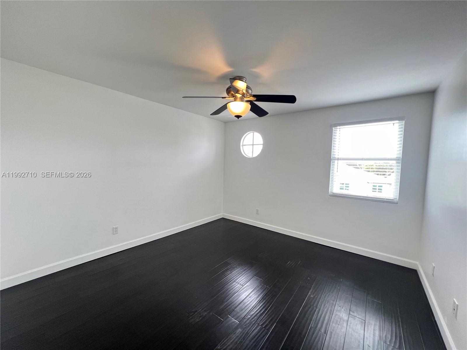 15511 Southwest 59th Street Miami, FL 33193 - Photo 26 of 34 a view of an empty room with wooden floor and a window